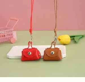 Detailed macro shot of red and brown mini PU leather coin purses featuring neck lanyards
