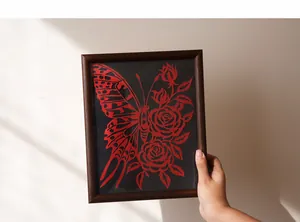 Détail d'une sculpture en papier faite main papillon rouge et rose dans cadre bois
