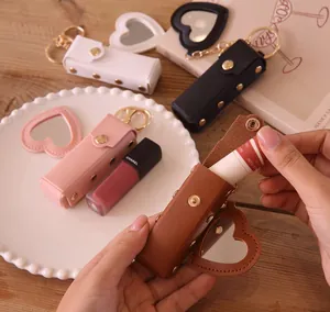 Detail of a portable PU leather lipstick case with heart mirror and golden keychain closure