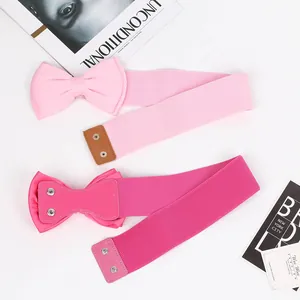 Macro detail of light pink and fuchsia elastic bow waist belts for stylish dresses.