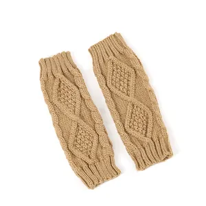 Détail des mitaines en tricot camel avec un motif classique de torsades en losange