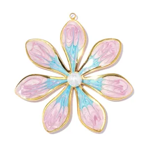 Macro view of a gold-plated stainless steel 7-petal enamel flower pendant with a white pearl