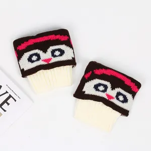 Détail de jolis couvre-bottes tricotés avec motif hibou et bordure côtelée crème.