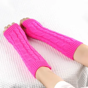 Dettaglio dei guanti lunghi senza dita in maglia a treccia rosa acceso sul braccio