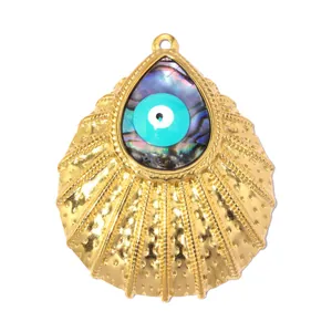 Detalle de colgante de vieira dorado con ojo de la suerte en concha de abulón natural