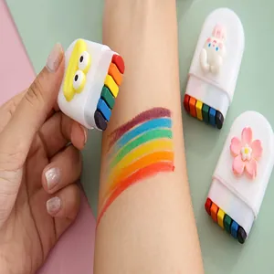 Close-up of 6-color rainbow face paint stick being applied to skin for Halloween makeup