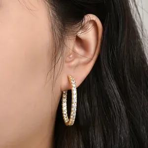 Detailansicht von 14 Karat vergoldeten Creolen mit funkelnden Kristallen am Modell