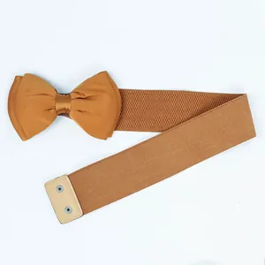 Detailed view of an elastic ginger-brown waist belt featuring a large chiffon bow.
