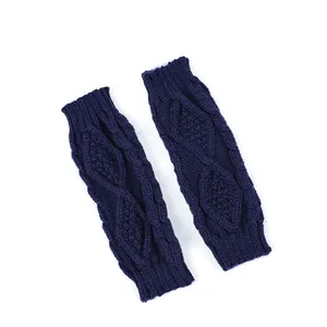 Texture détaillée du motif de torsades sur ces mitaines bleu marine pour les bras.