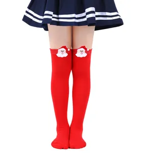 Detail of children's red over-the-knee Christmas socks with plush Santa Claus dolls