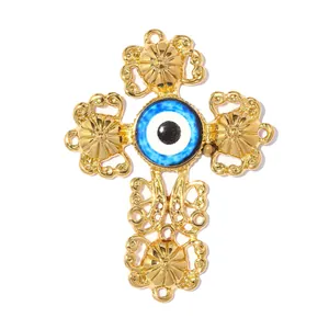 Detailed macro view of a golden stainless steel filigree cross pendant with a blue evil eye