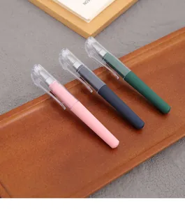 Close-up of portable mini gel pens in three stylish colors displayed on a wooden tray