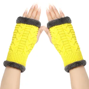 Detailed view of yellow thick knitted fingerless gloves with grey faux fur trim for winter.