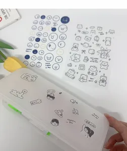 Close-up detail of cute cartoon stickers applied to a white minimalist pencil case