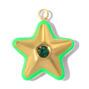 Macro view of a gold stainless steel star pendant with green enamel border and rhinestone