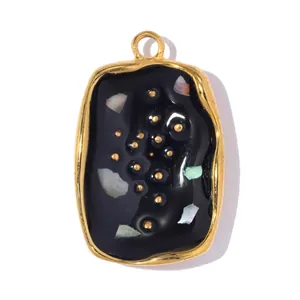 Close-up of square stainless steel pendant with black resin and shell inlay detail.