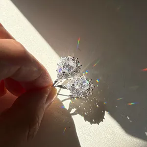 Vista macro de pendientes de moissanita con forma de copo de nieve y fuego brillante