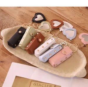 Macro view of multi-color heart-shaped leather lipstick case keychains with mirrors