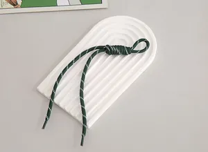 Close-up detail of a dark green and white braided nylon lanyard for phones or bags