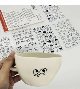 Macro view showing cute cartoon facial expression PVC stickers on a white ceramic mug