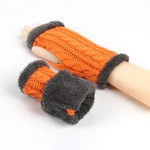 Détail des mitaines orange en maille torsadée avec bordure en fausse fourrure