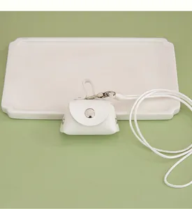 Close-up of a white mini PU leather coin pouch with hanging neck strap and snap button