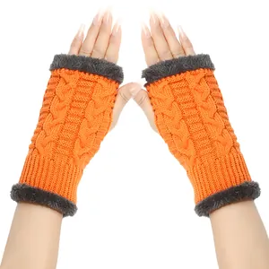 Orange cable knit fingerless gloves with grey faux fur trim showing warm winter texture.