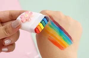 Detailed view of a portable 6-color rainbow face paint stick applying bright stripes.