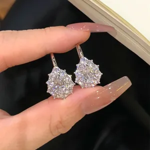 Primer plano de pendientes de moissanita con forma de copo de nieve y gota de agua brillante