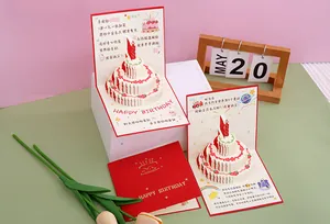 Close-up detail of a 3D pop-up birthday cake card with intricate paper-cut layers