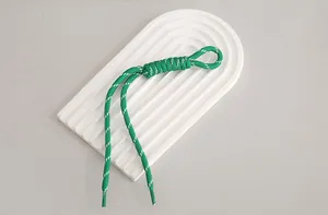 Close-up detail of a green and white braided nylon lanyard showing textured cord patterns