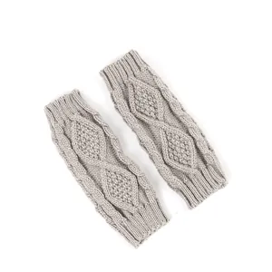 Gros plan détaillé de mitaines en tricot gris avec un motif de torsades en losange