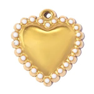 Détail macro d'un pendentif en forme de cœur doré avec une bordure de perles blanches