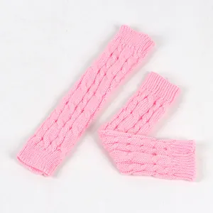Vista dettagliata degli scaldabraccia in maglia a trecce rosa con motivo a lana intrecciata