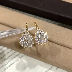 Vista detallada de pendientes de moissanita brillantes en un diseño de gota de nieve dorada