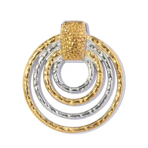 Detailed macro view of a multi-layer textured gold and silver stainless steel circular pendant