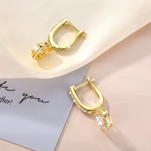 Nahaufnahme von eleganten 14k goldgefüllten Moissanit-Creolen mit Halo-Anhänger-Detail