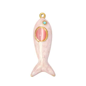 Vista dettagliata di un ciondolo a forma di pesce rosa con pietra occhio di gatto e occhio turchese