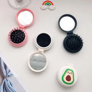 Compact folding travel mirror and hairbrush combo with cute cartoon avocado design.
