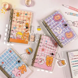Close-up of cute cartoon bear and rabbit loose-leaf handbooks with matching pendants