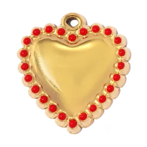 Vue détaillée d'un pendentif en forme de cœur doré avec une bordure perlée rouge