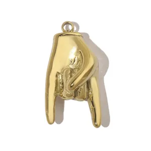 Gros plan d'un pendentif en acier titane plaqué or en forme de main avec finition brillante