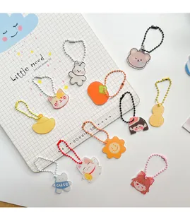 Selectie schattige acryl sleutelhangers met konijn, beer en fruit vormen met gekleurde kettingen.