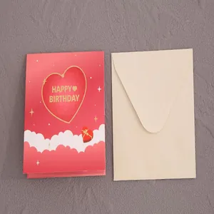 Κοντινό πλάνο κόκκινη κάρτα γενεθλίων με καρδιά και ιβουάρ φάκελο