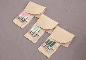 Vista dettagliata di tre set manicure portatili in astucci di pelle beige in vari colori