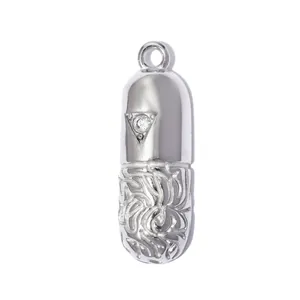 Detailed macro view of silver capsule pendant with intricate hollow pattern and zircon inlay