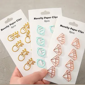 Detailed shot of novelty pineapple, planet, and diamond-shaped metal paper clips
