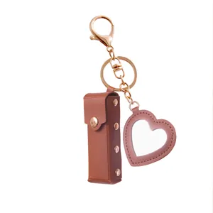 Portable leather lipstick case keychain with a heart-shaped mirror in brown finish