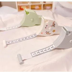 Detail view showing three colorful mini portable retractable soft measuring tapes on white cloth