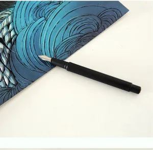 Gros plan d'un stylet de grattage professionnel à pointe métallique sur papier bleu